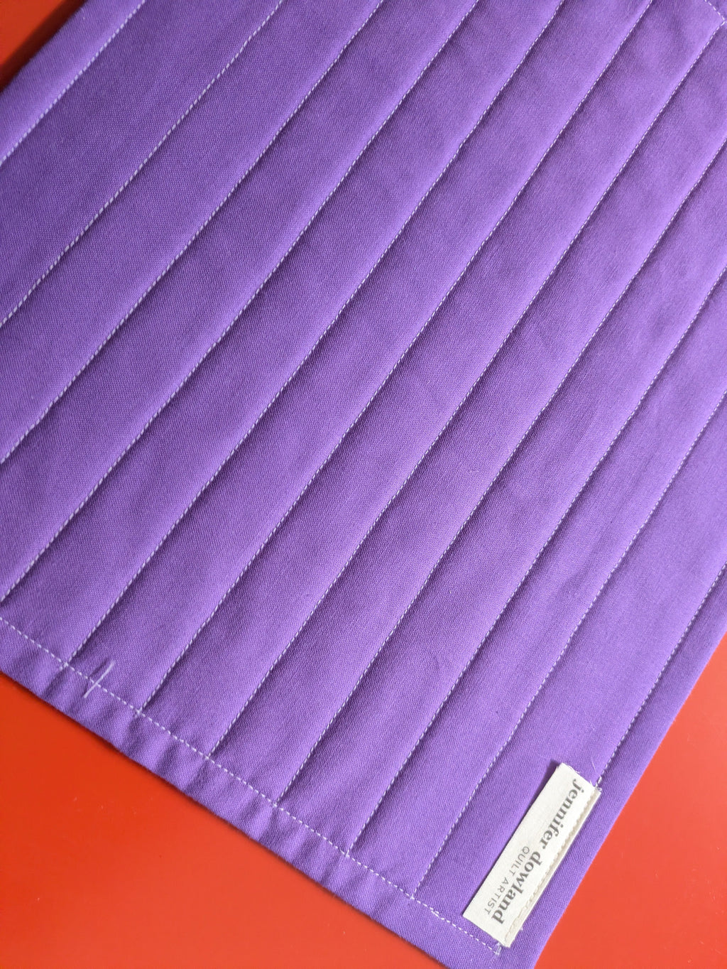Close-up of a purple fabric with a brand label on a red background
