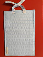 Light blue hanging quilt with floral ribbon 