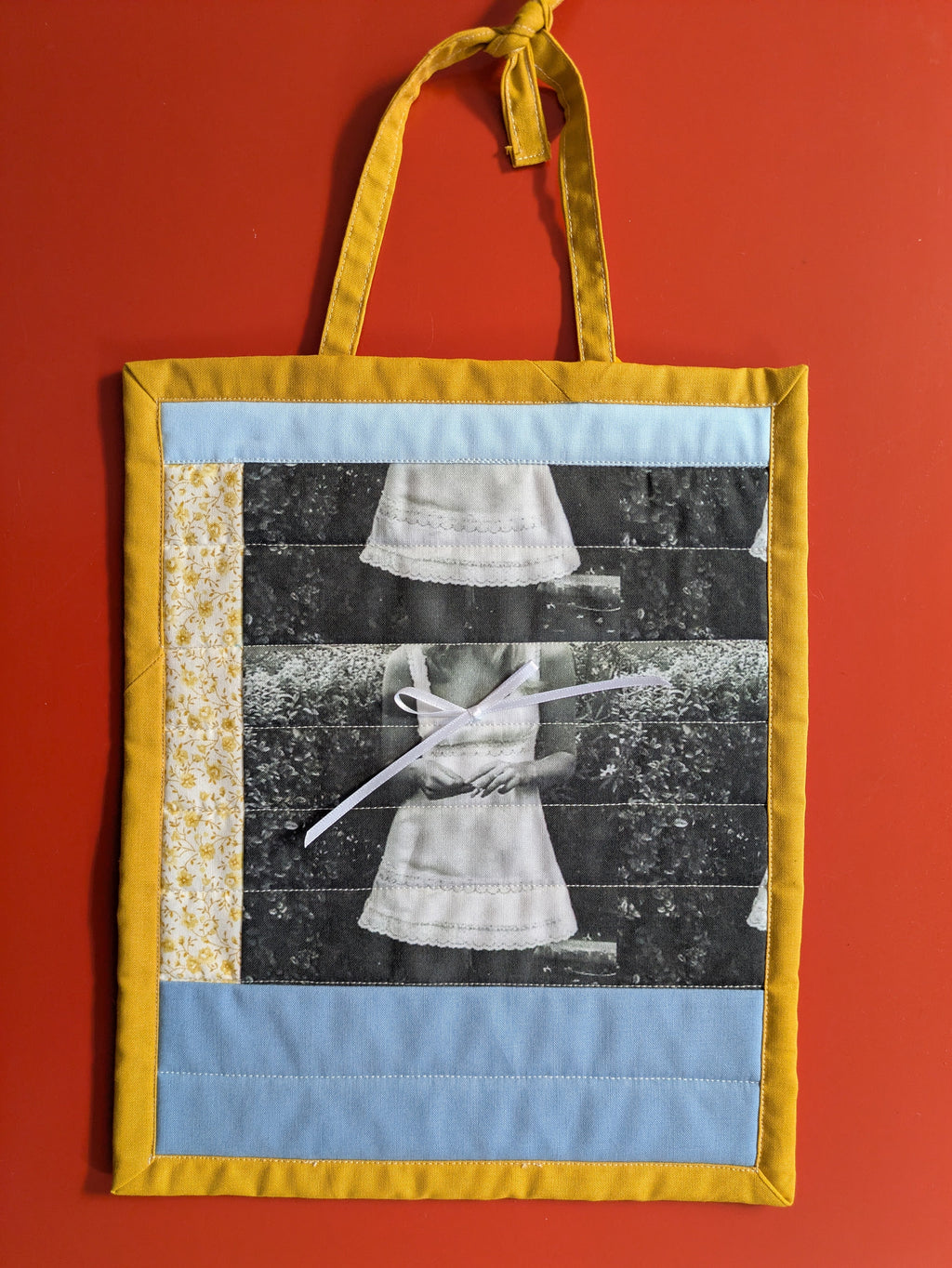 Fabric wall art with a collage of images on a red background