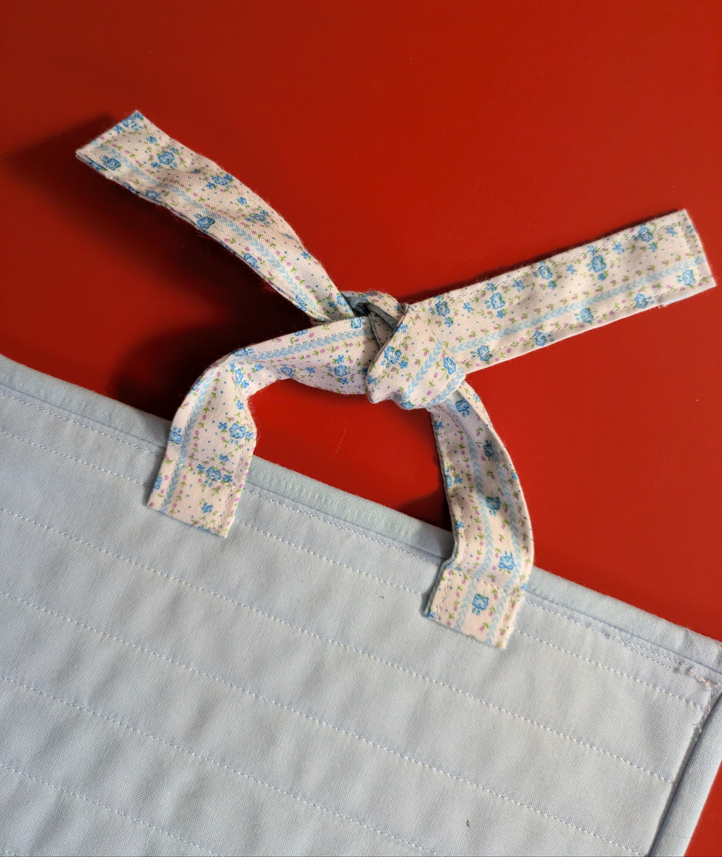 Light blue fabric with a tied floral ribbon 