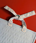 Light blue fabric with a tied floral ribbon 