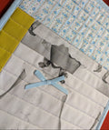 Quilt with fabric patchwork featuring a bow and printed patterns